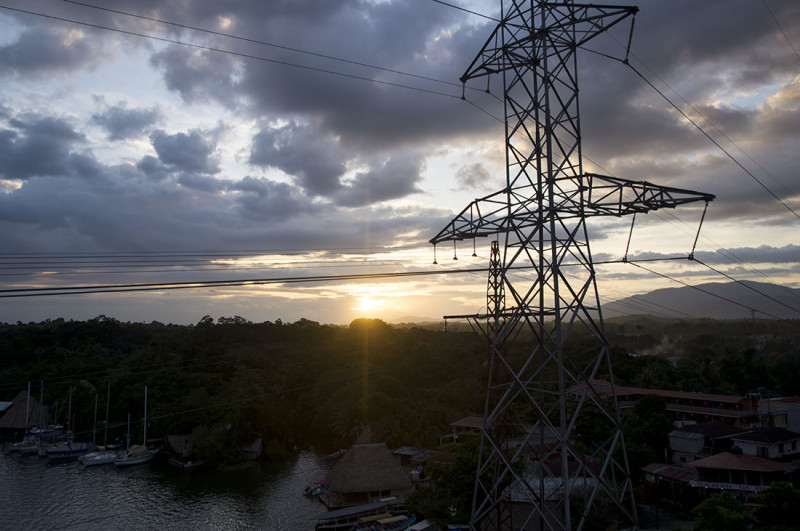 sun sets behind power lines, Rio Dulce, Guatemala